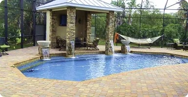 Paver pool deck around a stone-column cabana