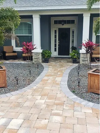 Curved paver front walkway lined with planter boxes